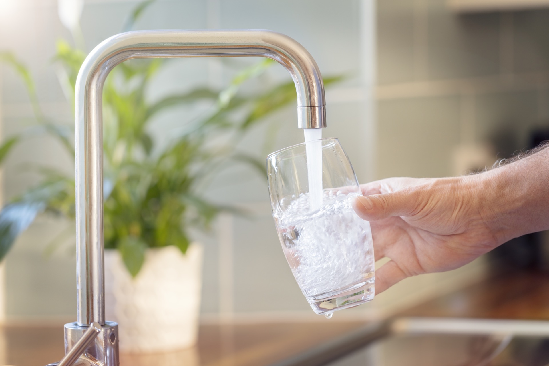 Glas füllen an Wasserhahn